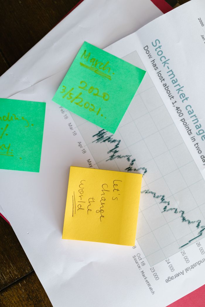 Top-view of colorful sticky notes on a stock market graph paper, symbolizing business and financial planning.